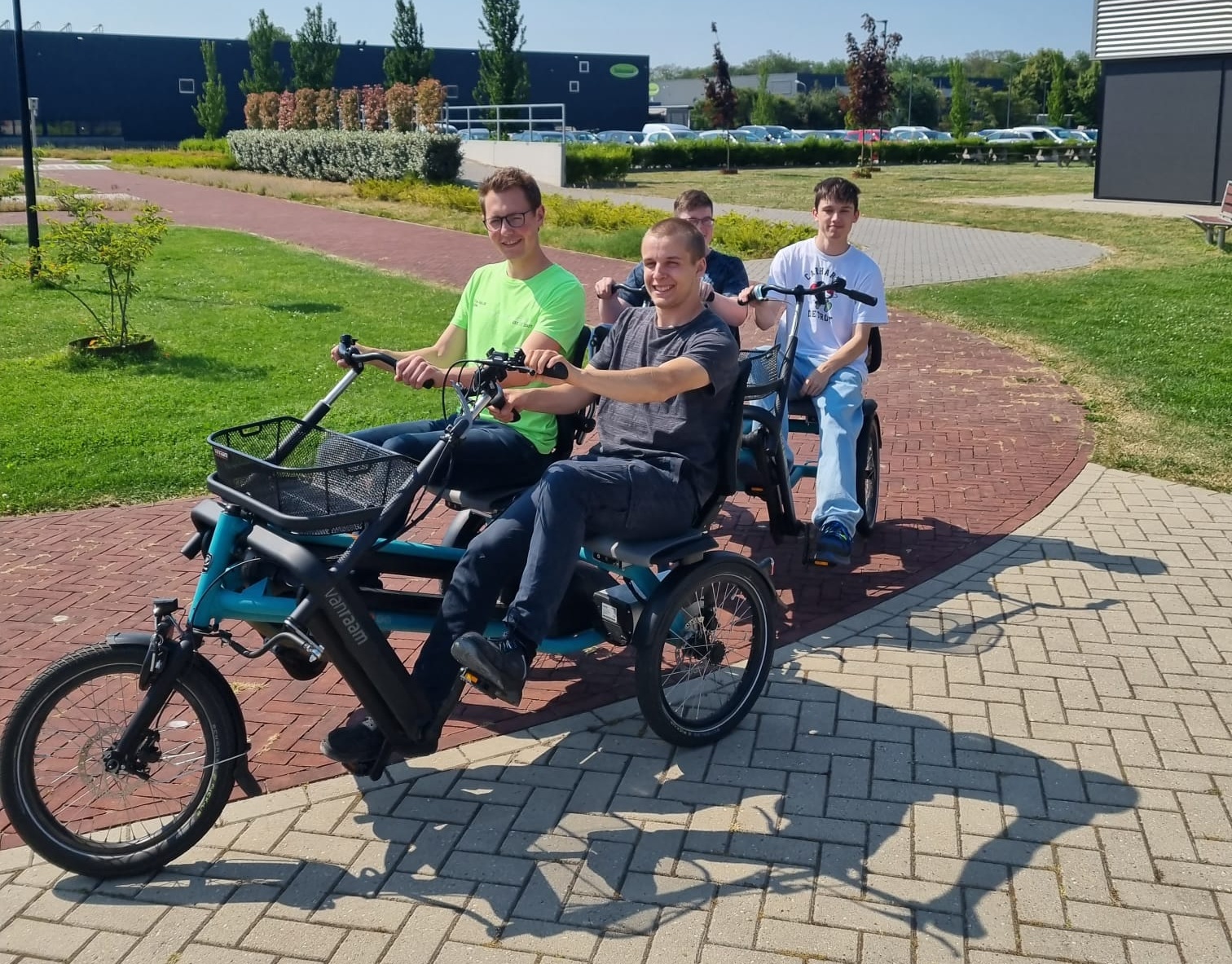 Vier Personen fahren mit zwei Fahrzeugen mit Fahrradantrieb.