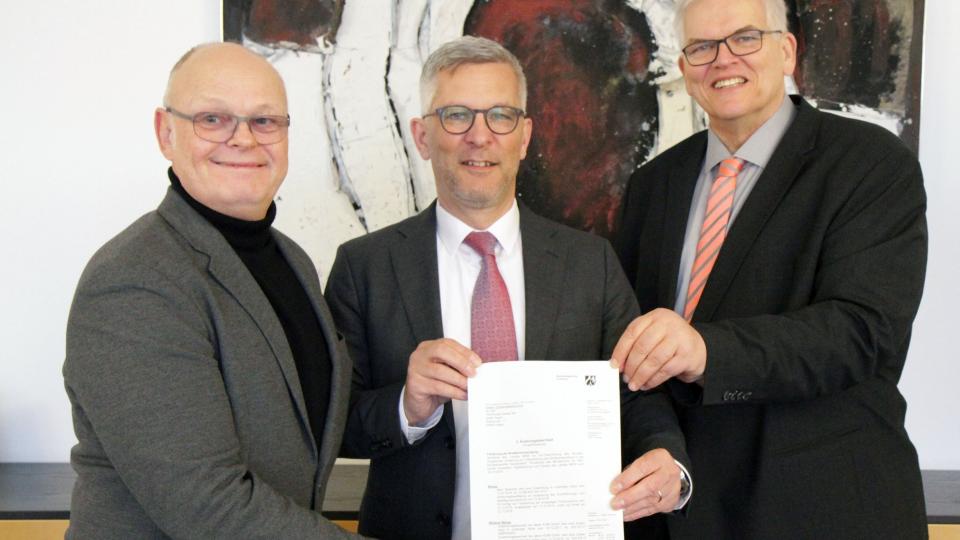 (v.l.n.r.) Hagens Breitbandkoordinator Bertram Schmidtke, Oberbürgermeister Erik O. Schulz und Regierungspräsident Hans-Josef Vogel mit dem Förderbescheid.