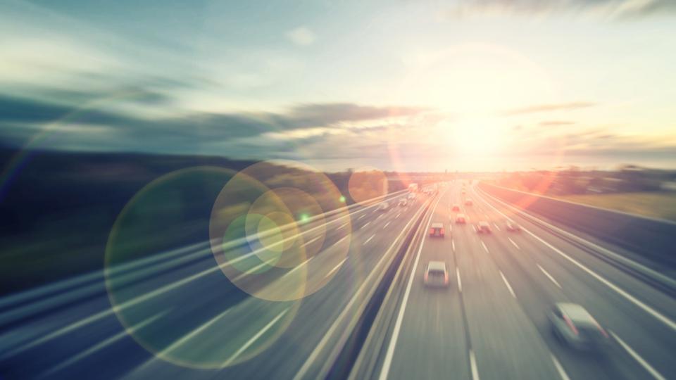 Ein leicht verzerrter Autobahnabschnitt, auf dem einige Autos fahren. 