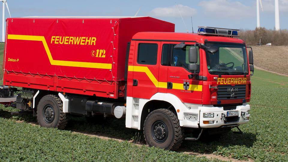 Das Bild zeigt ein Einsatzfahrzeug der Feuerwehr auf einem Feld.