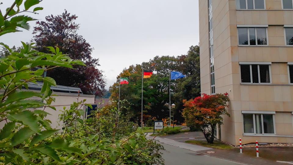 Die Flaggen von Nordrhein-Westfalen, der Bundesrepublik Deutschland und der Europäischen Gemeinschaft von einem Dienstgebäude der Bezirksregierung.