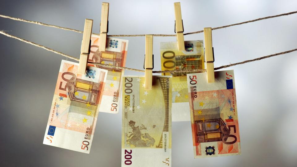 Einige Euro-Scheine, die an einer Wäscheleine mit Klammern aufgehängt wurden.