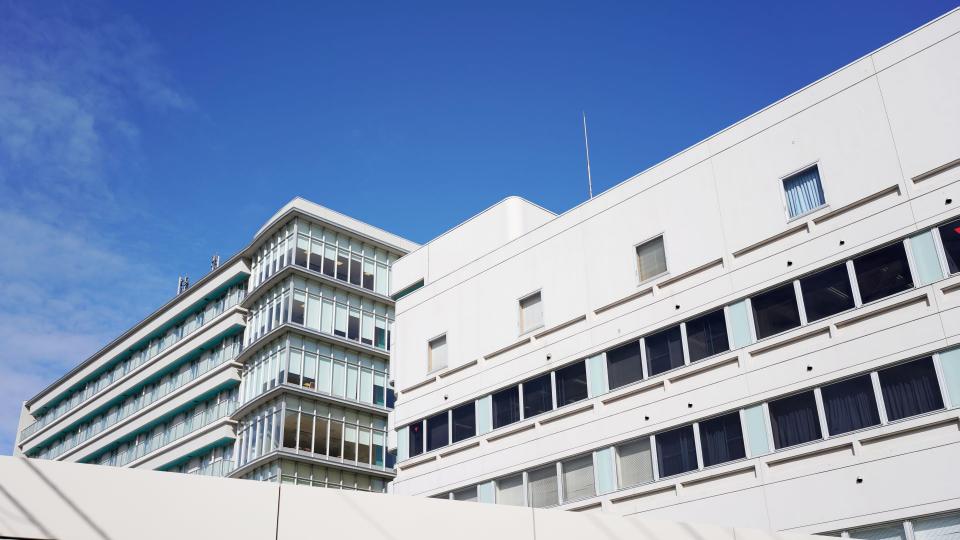 Ein mehrstöckiges Schulgebäude bei blauem Himmel