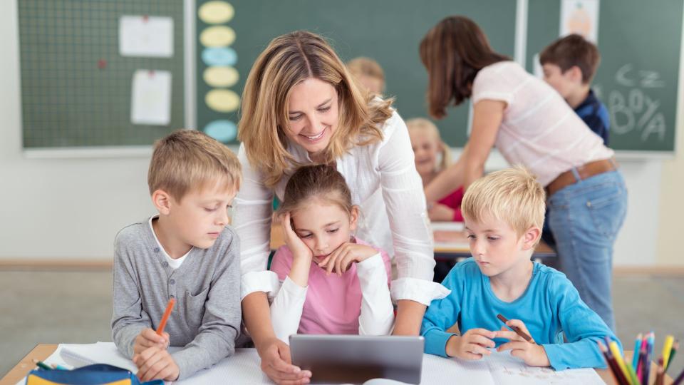 Eine Lehrerin erklärt Ihren Schüler Schulstoff anhand eines Tablets