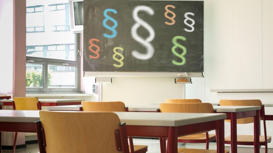 Ein Klassenraum mit einer bemalten Tafel im Hintergrund