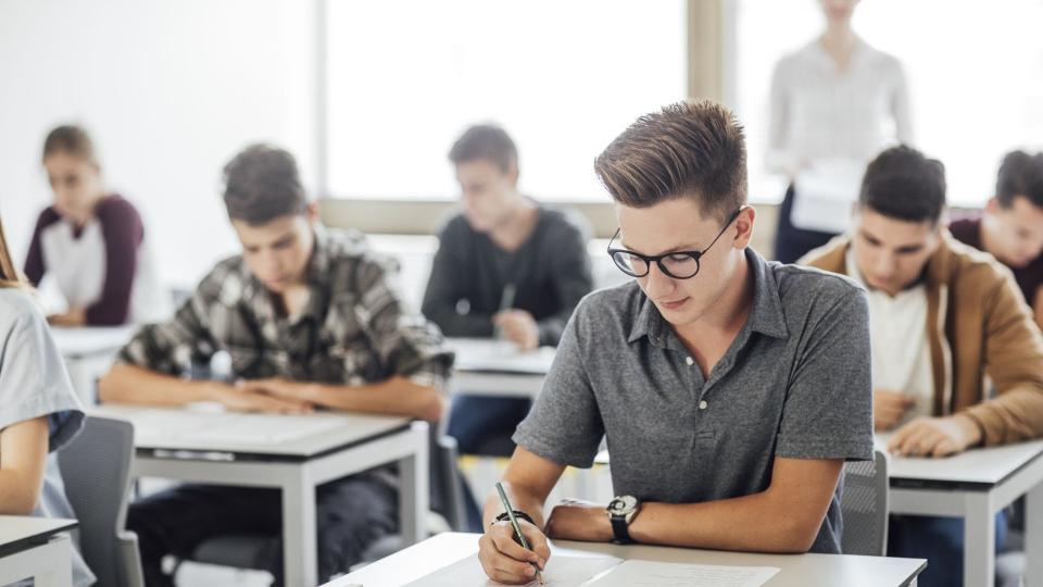 Eine Gruppe von Schülern schreiben einen Test in einem Klassenraum