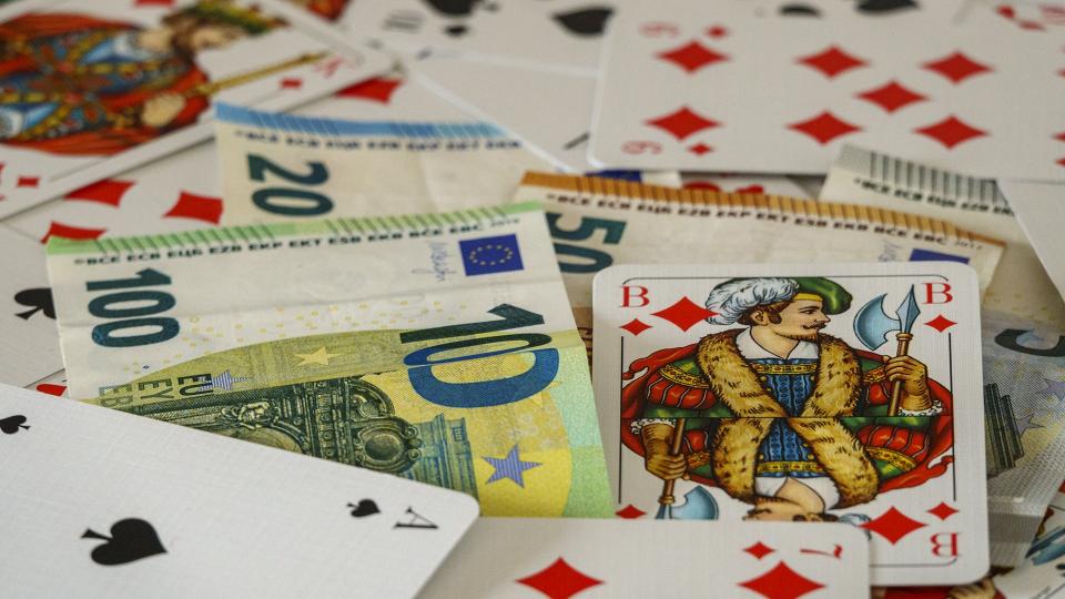 Abgebildet sind Spielkarten und Euro-Banknoten.