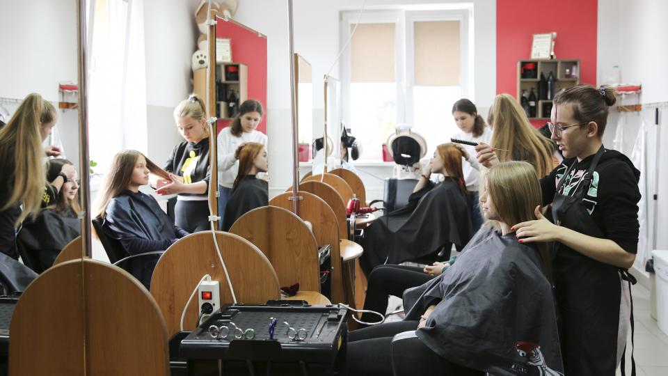 Jugendliche Auszubildende arbeiten im Rahmen des Technikum im Friseursalon in Polen.
