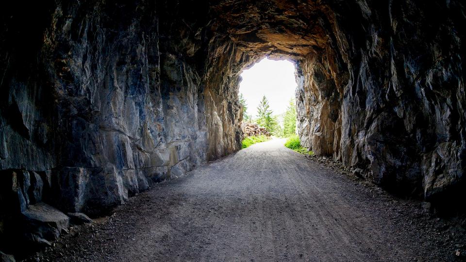 Abgebildet ist das Innere eines Tunnels mit Blick in Richtung Ausgang.