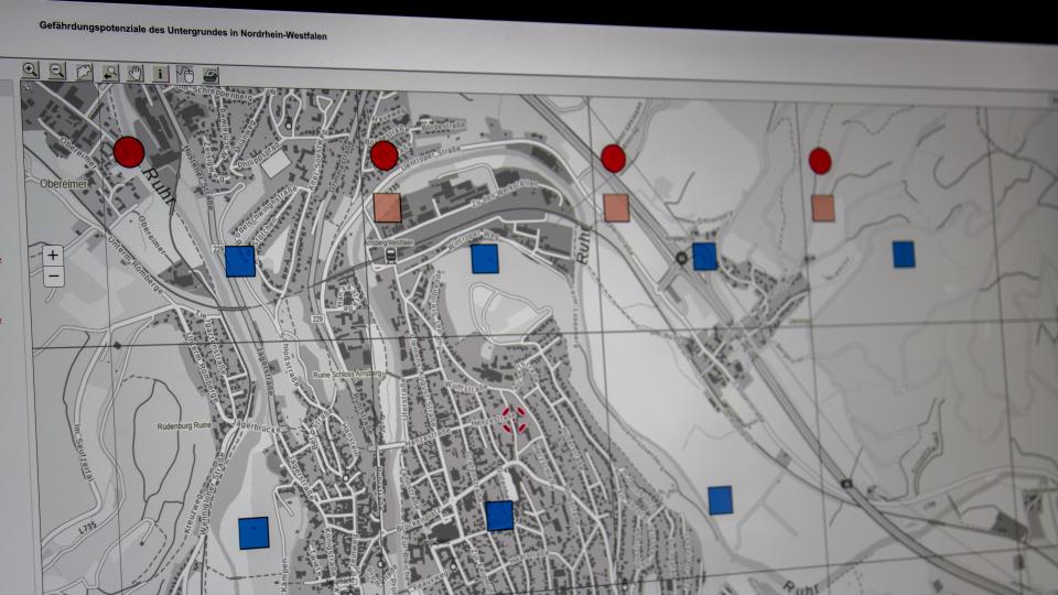Blick auf einen Monitor, der eine Karte mit farbigen Punkten und Quadraten zeigt.