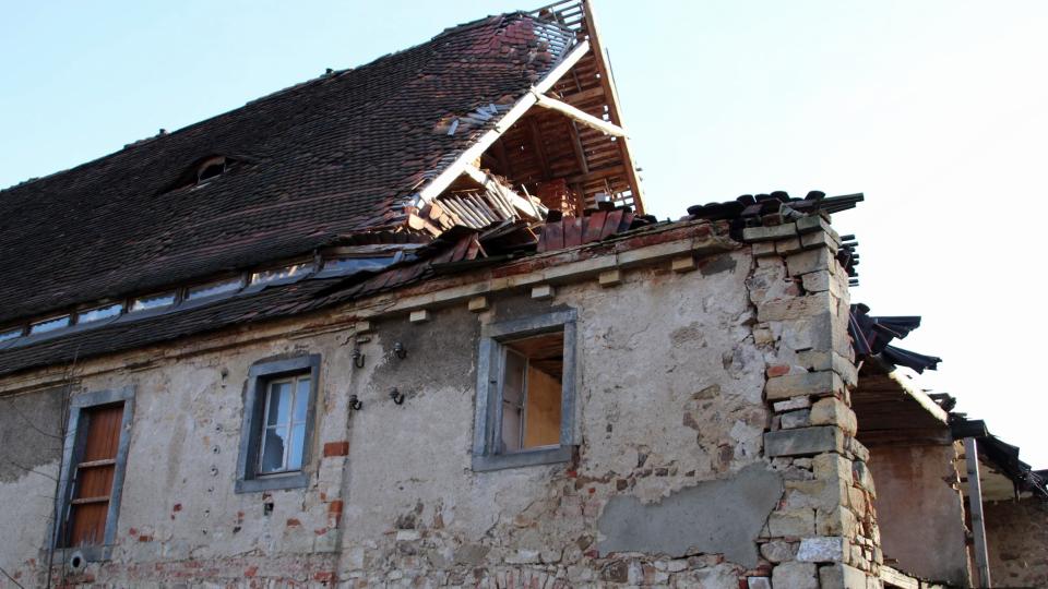 Ein verfallenes Haus mit einem teilweise eingestürzten Dach.