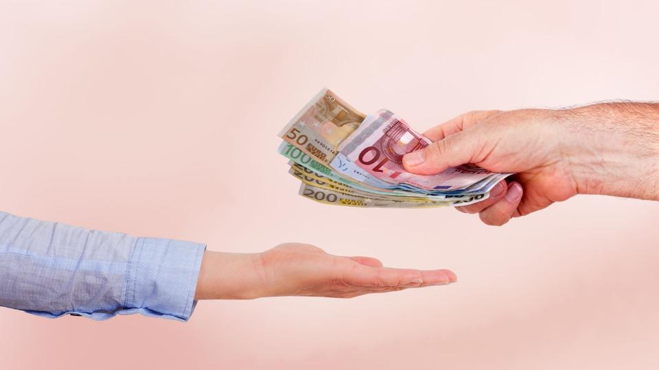 Abgebildet sind zwei Hände von unterschiedlichen Personen. In der oberen Hand befinden sich 800 Euro in bar. Die Handfläche darunter ist geöffnet, sodass das Geld von der oberen in die untere Hand übergeben werden kann.