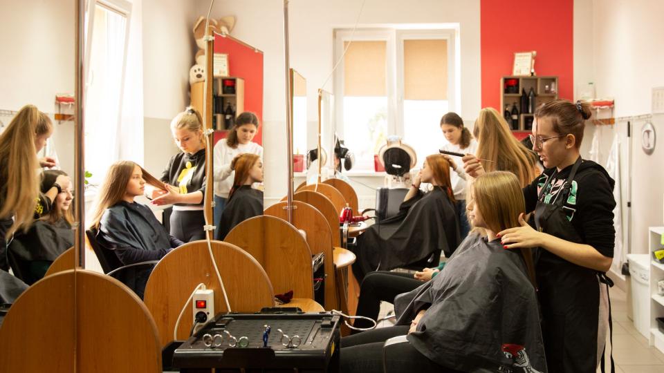 Jugendliche Auszubildende arbeiten im Rahmen des Technikums im Friseursalon in Polen 