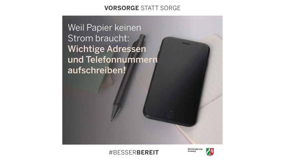 Abgebildet sind ein Smartphone, ein Kugelschreiber und ein Heftchen sowie der Text "Weil Papier keinen Strom braucht: Wichtige Adressen und Telefonnummern aufschreiben!"