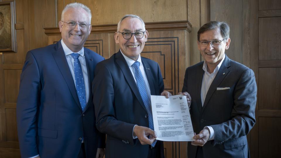 Regierungspräsident Heinrich Böckelühr (m.) übergibt die Haushaltsgenehmigung an Oberbürgermeister Dr. Frank Dudda (r.) und an Stadtdirektor und Kämmerer Dr. Hans Werner Klee 