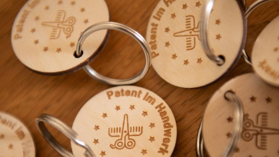 Abgebildet sind Schlüsselanhänger mit dem Logo von Patent im Handwerk.