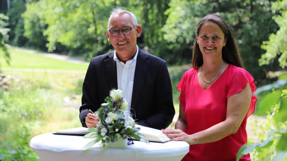 Regierungspräsident Heinrich Böckelühr trägt sich ins Goldene Buch der Stadt Ennepetal ein, neben ihm Bürgermeisterin Imke Heymann