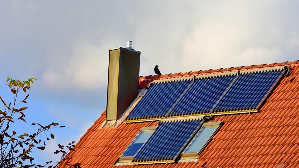 Teil einer Dachfläche auf der Solarthermie-Röhrenkollektoren angebracht sind