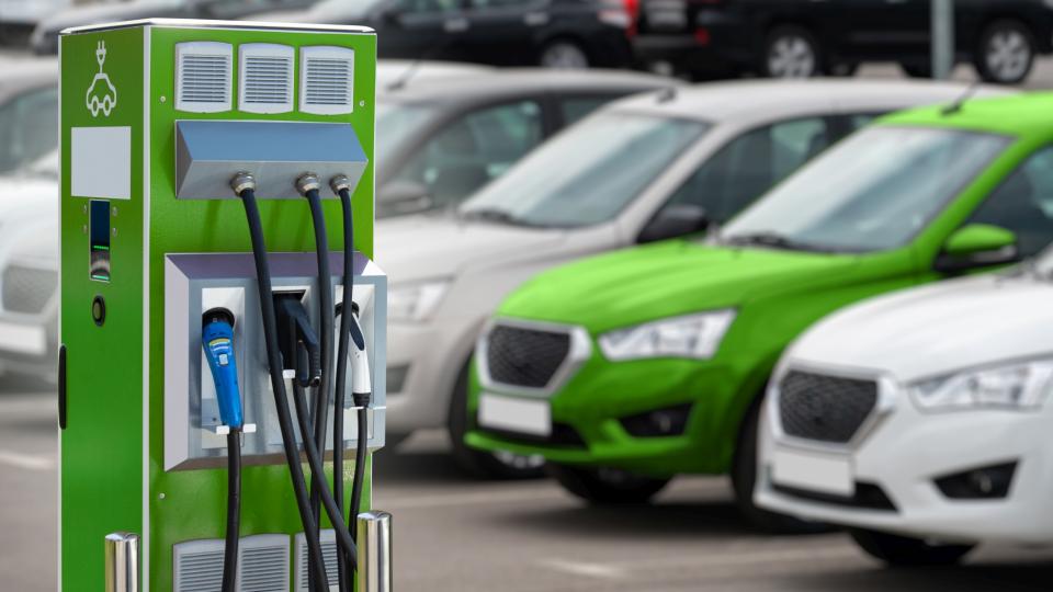 Ladestation für Elektrofahrzeuge vor dem Hintergrund einer Reihe von Autos.