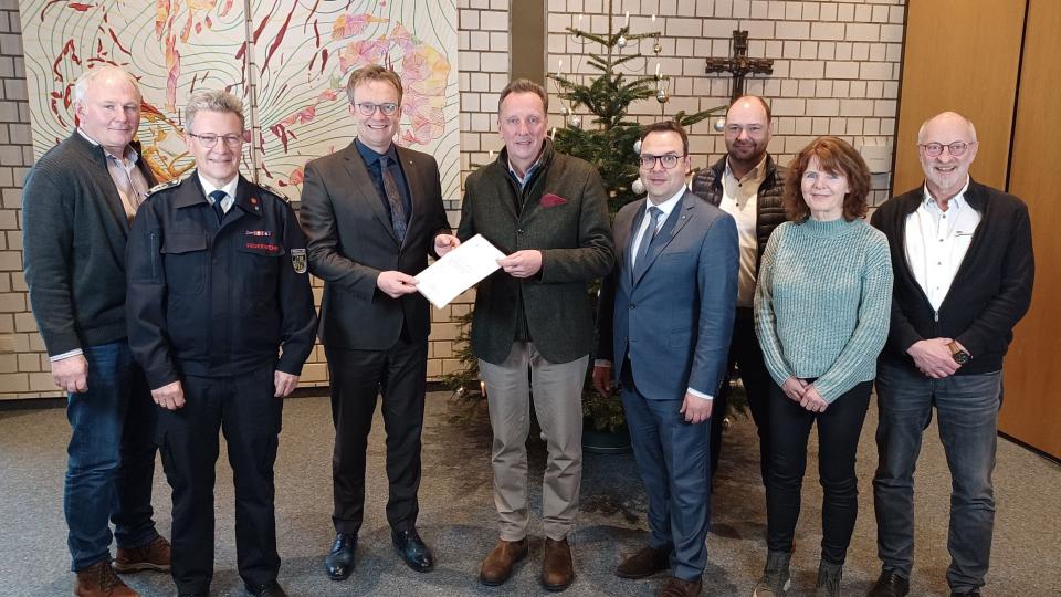 Förderbescheid-Übergabe in Lennestadt – mit dabei waren (v.l.n.r.) Peter Quinke (Leiter Stadtwerke), Markus Hamers (Leiter der Feuerwehr), Bürgermeister Tobias Puspas, Thomas Sommer von der Bezirksregierung, Karsten Schürheck (Beigeordneter), Stefan Müller (Bereichsleiter Sicherheit und Ordnung), Martina Dobbener (Bereichsleiterin Bauverwaltung, zuständig für Förderprogramme), Jochen Biermann (Kämmerer)