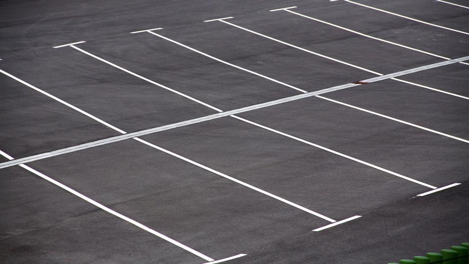 Abgebildet ist ein Parkplatz mit mehreren Stellplätzen. 