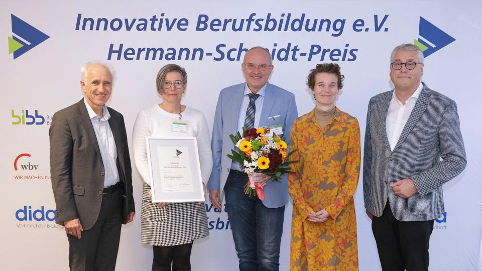 v.l.nr.: Verleihung des Hermann-Schmidt-Sonderpreises 2023 an Andrea Stein (2.v.l.) und Karsten Mielke (M.) von der EU-Geschäftsstelle Wirtschaft und Berufsbildung der Bezirksregierung Arnsberg, weitere Personen: Arndt Bertelsmann (l.), Dr. Johanna Börsch-Supan (2.v.r.) und Hubert Esser (r.)