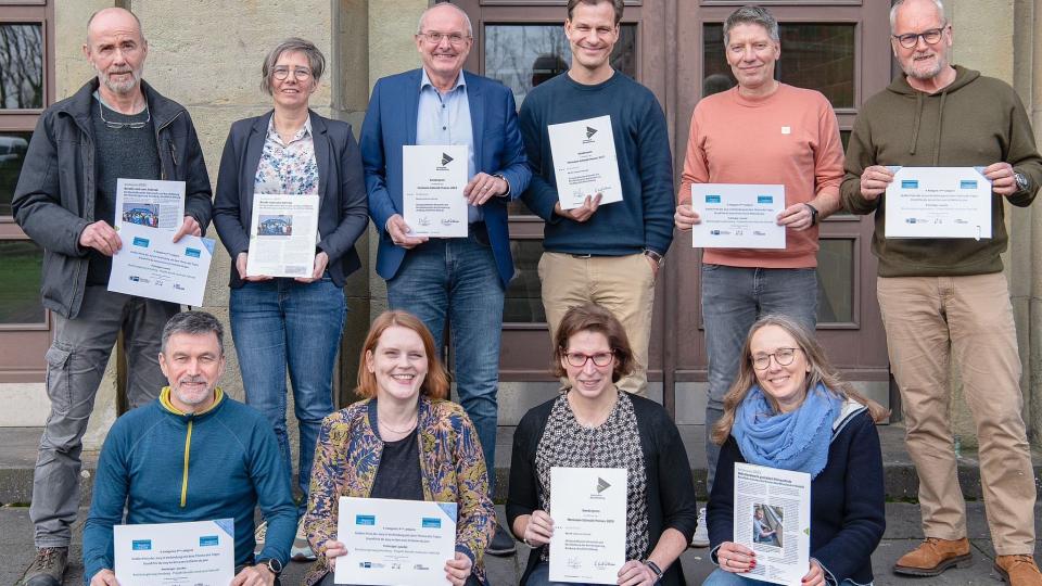 Abgebildet sind die Akteurinnen und Akteure von „Berufe rund ums Rad“, die stolz ihre Urkunden präsentieren.
