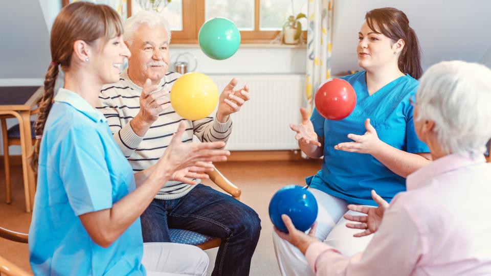 Eine Gruppe von Senioren macht Sport und Gymnastik mit Bällen.