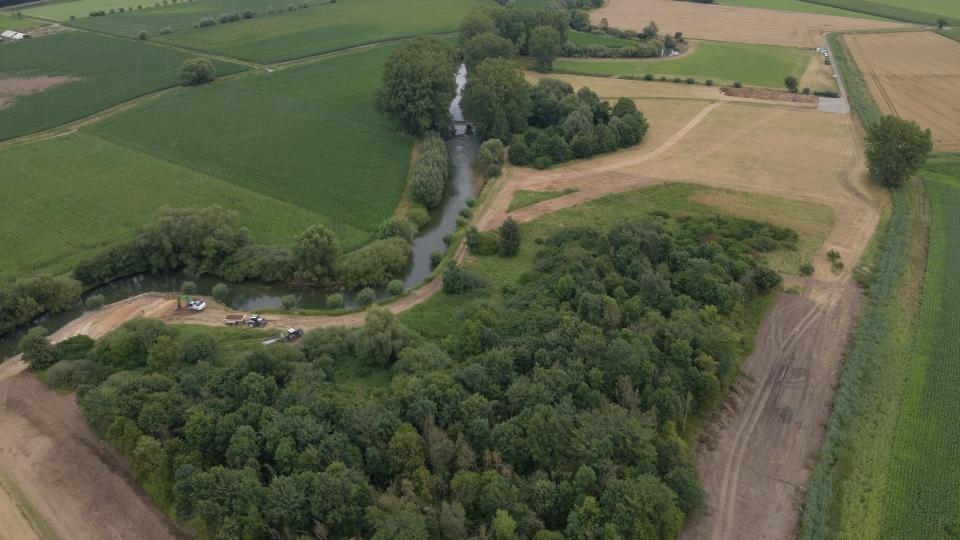 Luftaufnahme eins Flusses mit Erdarbeiten am Ufer