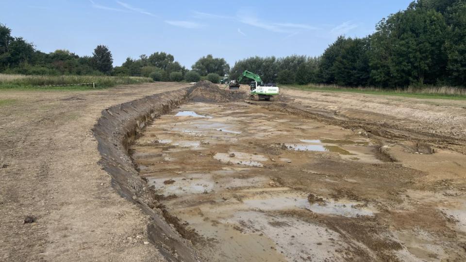 Ein Bagger arbeitet in dem neuen Flusslauf
