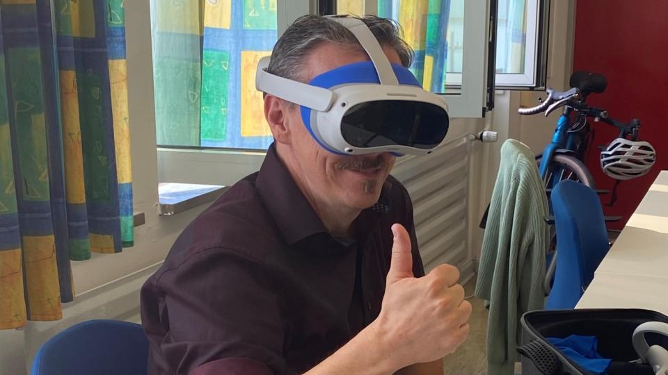 Eine Person mit VR-Brille zeigt einen Daumen hoch
