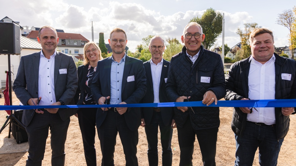 Gruppenbild beim Zerschneiden eines blauen Bandes