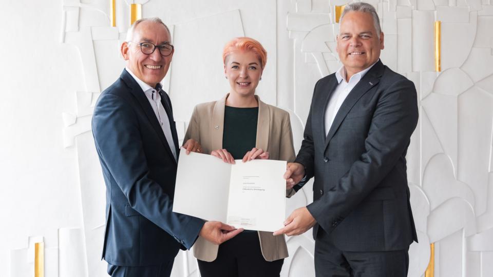 Gruppenbild: Regierungspräsident Heinrich Böckelühr überreicht in Anwesenheit von Olaf Stelse (Bürgermeister Kierspe, r.) eine öffentliche Belobigung an Julia Schoenfuß für eine Rettungstat
