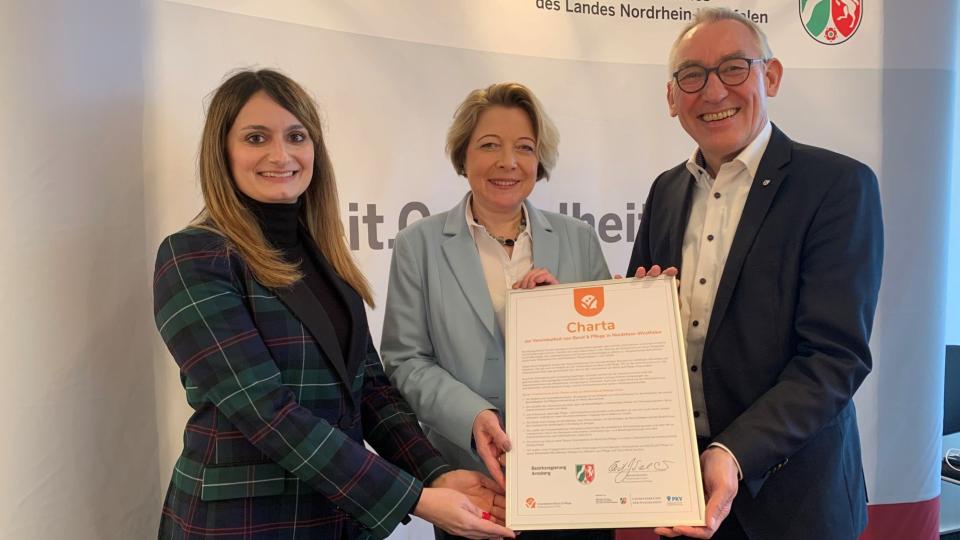Heinrich Böckelühr präsentiert mit Heike Weiß (Mitte), Leiterin der Abteilung Pflege und Alter beim Ministerium für Arbeit, Gesundheit und Soziales NRW, und Anahita Roßmann, Leiterin des Büros des Regierungspräsidenten, die Charta zur „Vereinbarkeit von Beruf & Pflege“.