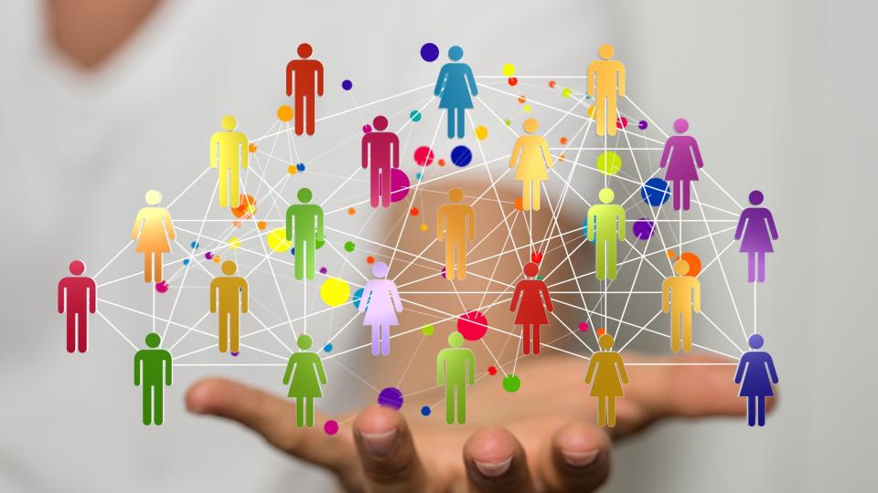 Vernetzte Icons von Personen in der Hand eine unscharf dargestellten Person.