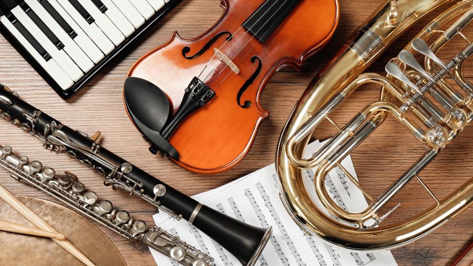 Abgebildet sind mehrere Musikinstrumente und ein Notenblatt.