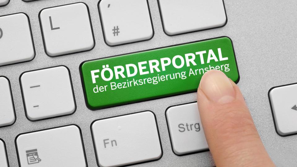 Eine Tastatur, auf der die Entertaste grün ist und mit dem Text Förderportal der Bezirksregierung Arnsberg versehen ist