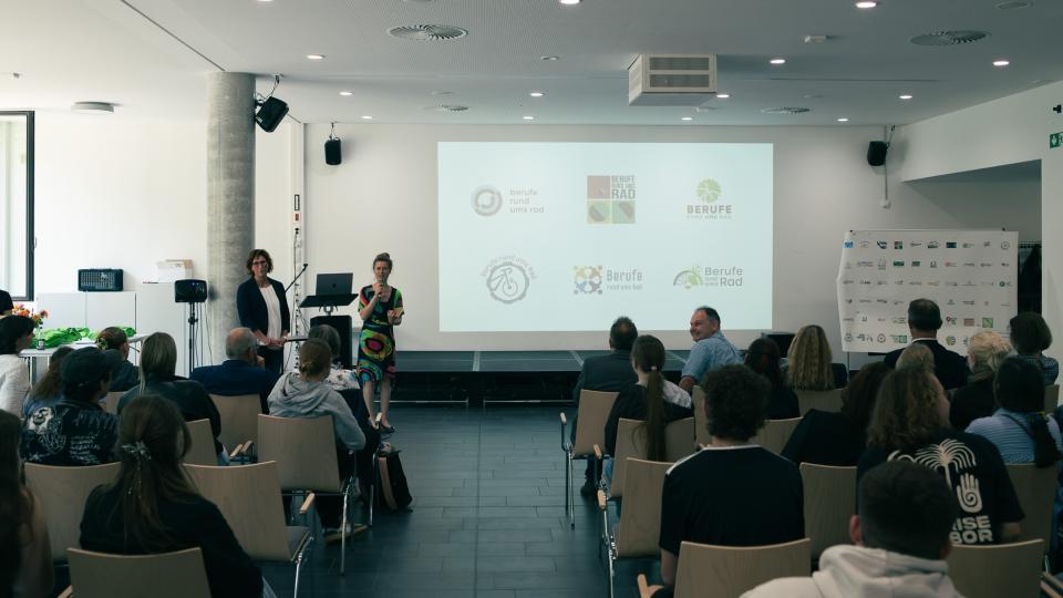 Abgebildet sind Impressionen zur Preisverleihung im internationalen Logowettbewerb „Berufe rund ums Rad“.