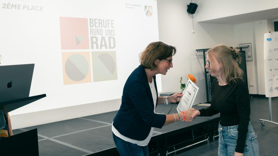 Abgebildet sind Impressionen zur Preisverleihung im internationalen Logowettbewerb „Berufe rund ums Rad“.