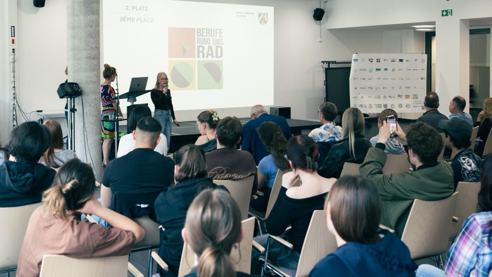 Abgebildet sind Impressionen zur Preisverleihung im internationalen Logowettbewerb „Berufe rund ums Rad“.