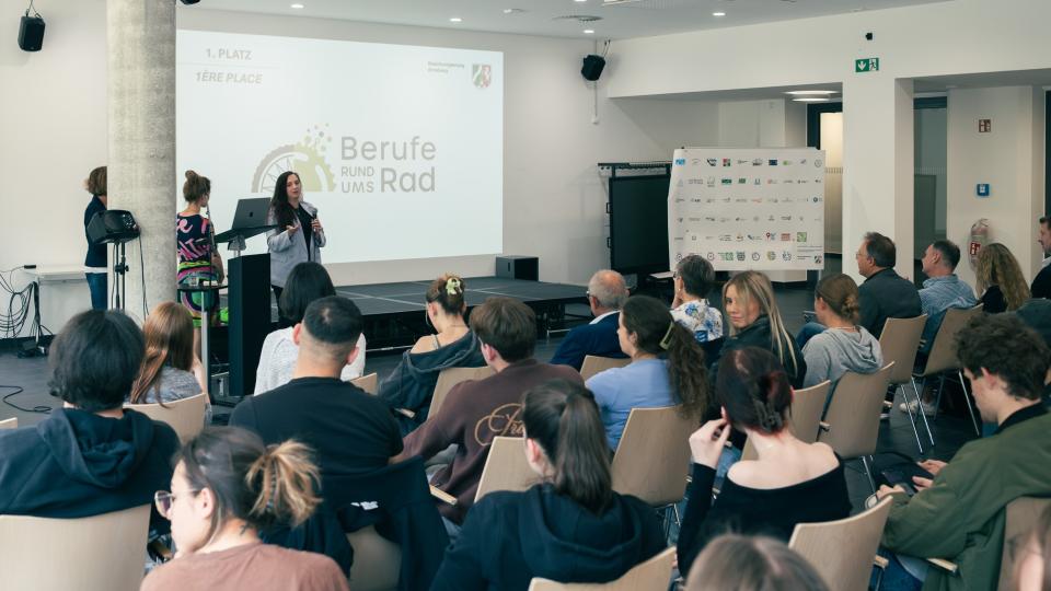 Abgebildet sind Impressionen zur Preisverleihung im internationalen Logowettbewerb „Berufe rund ums Rad“.