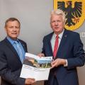 Regierungsvizepräsident Volker Milk (links) übergibt zwei Förderbescheide an den Dortmunder Oberbürgermeister Ullrich Sierau