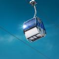 Bild der Gondel einer Seilbahn vor blauem Himmel.