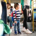 Ein kleiner Junge an der Hand seiner Mutter in einer Straßenbahn.