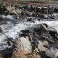 Ein reißender Fluss mit viele großen Steinen im Flussbett im Herbst