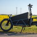 Ein elektrisches Lastenfahrrad steht auf einer Straße