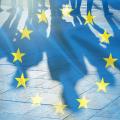 EU-Flagge halbtransparent über den Schatten einer Menschenmenge gelegt