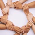 Hände von Menschen, die Handgelenke voneinander halten, um einen Kreis zu bilden