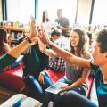 Eine Gruppe von Schüler*innen gibt sich High-Five.