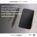 Abgebildet sind ein Smartphone, ein Kugelschreiber und ein Heftchen sowie der Text "Weil Papier keinen Strom braucht: Wichtige Adressen und Telefonnummern aufschreiben!"